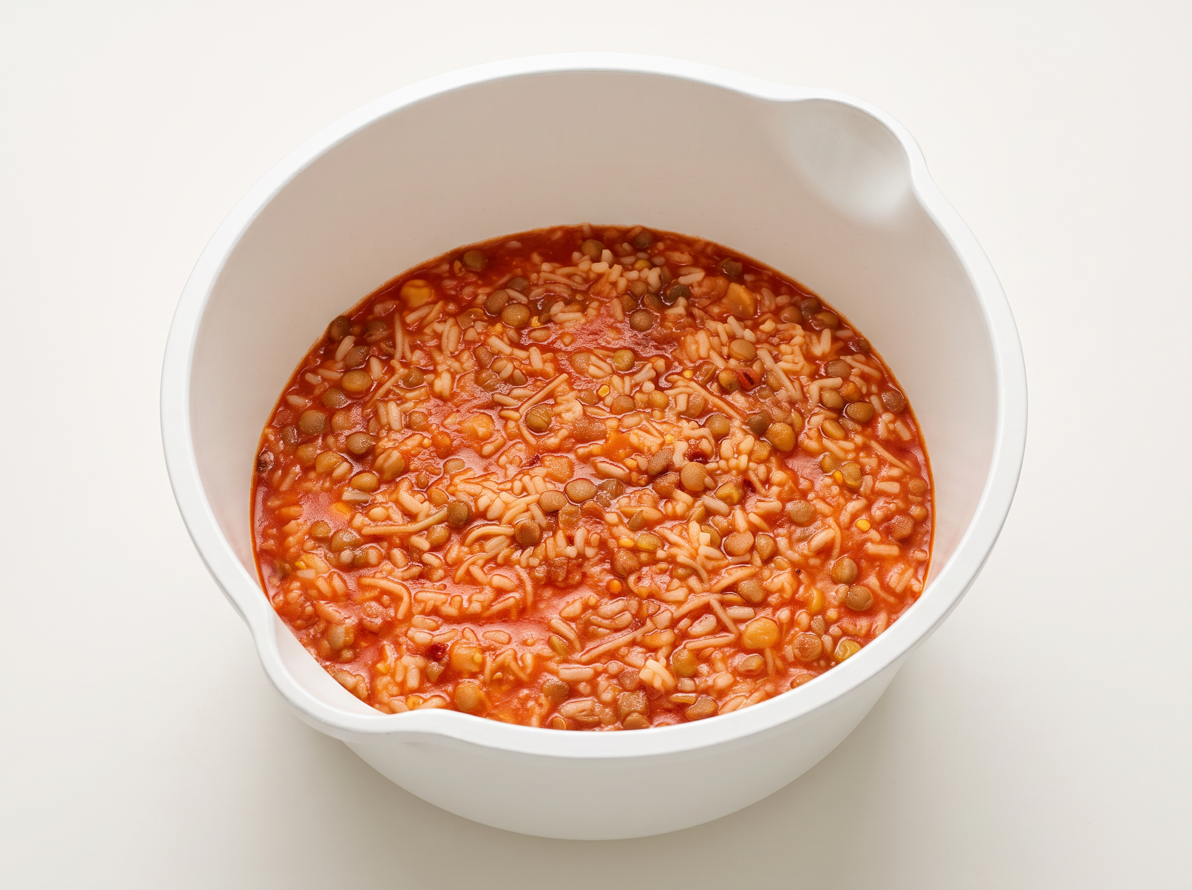 Koshary simmering in a pot with tomato-spice mix